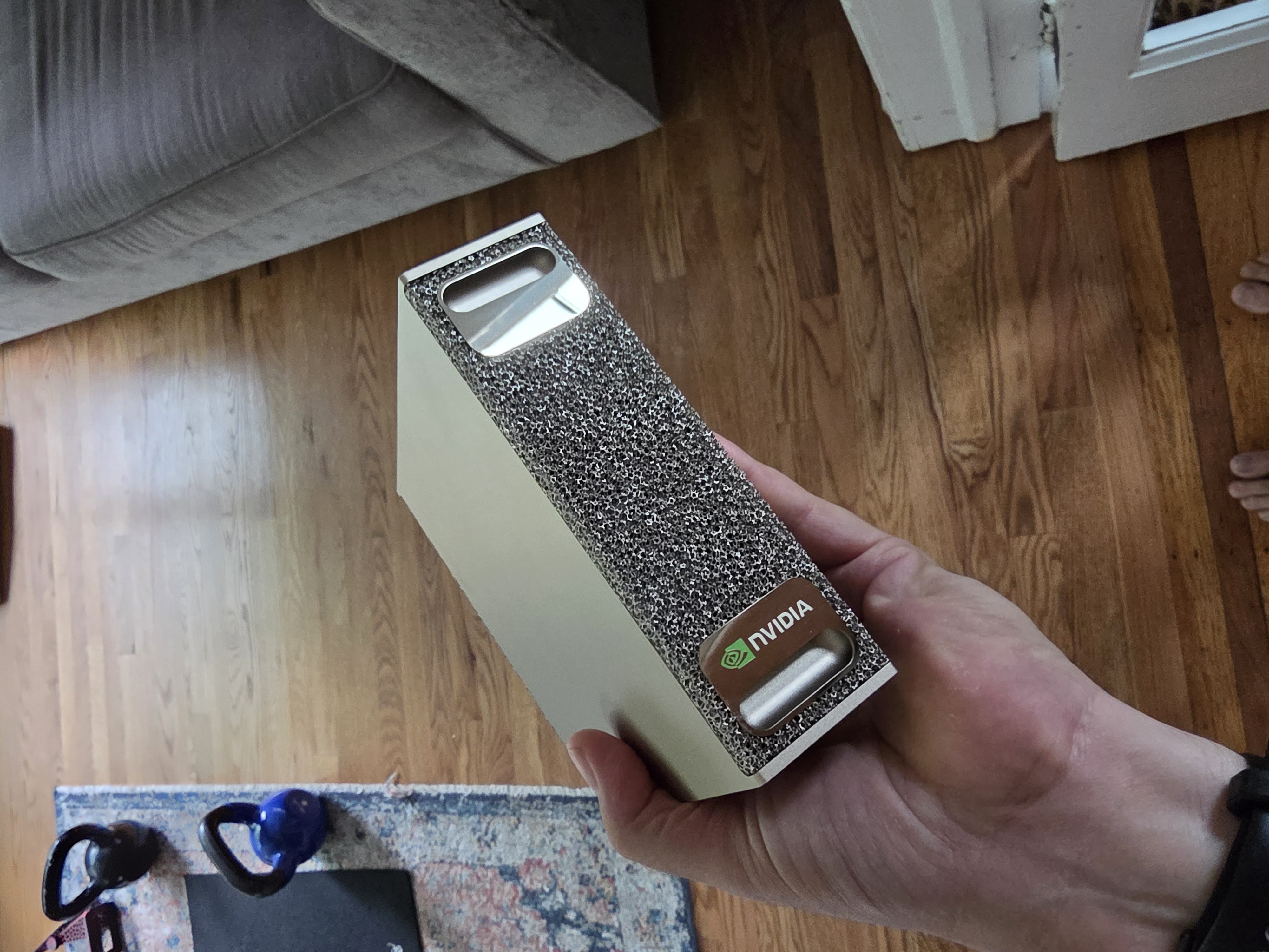 Holding the whole thing in one hand — a genuine AI supercomputer that fits in your palm